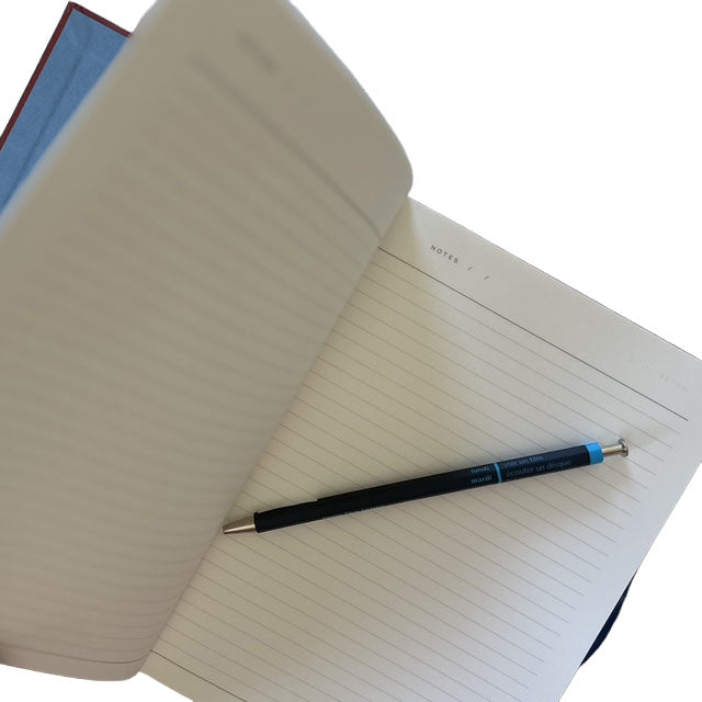 Open notebook with a navy pen on a white background