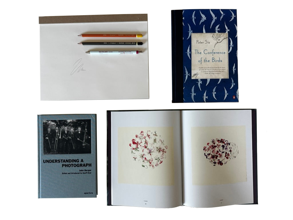 Collection of books and stationery items including pencils and a notebook with a cover design.