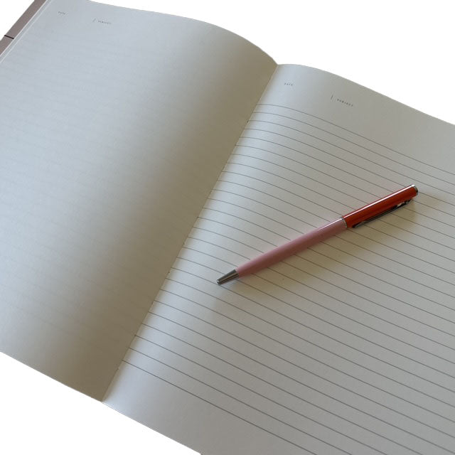 Open notebook with a pink pen on a white background