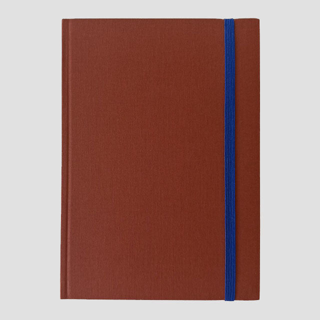 Sienna notebook with a blue strap on a light gray background