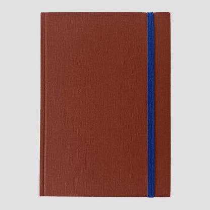 Sienna notebook with a blue strap on a light gray background