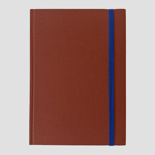 Sienna notebook with a blue strap on a light gray background