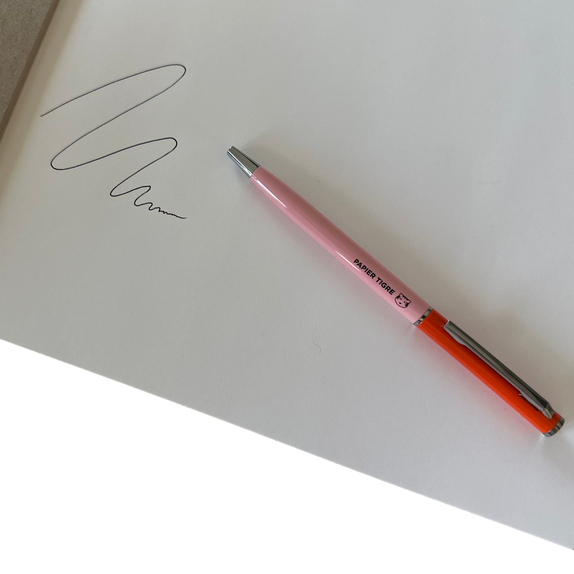 Pink and red pen on white paper with ink drawing