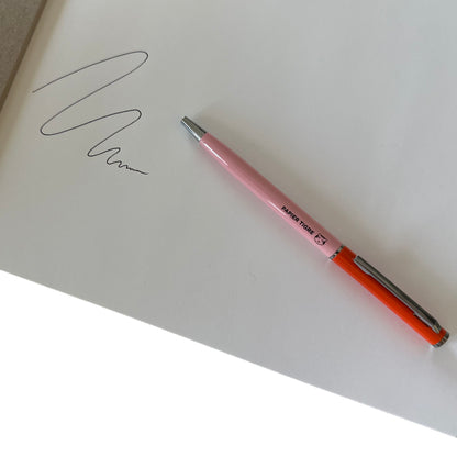 Pink and red pen on white paper with ink drawing