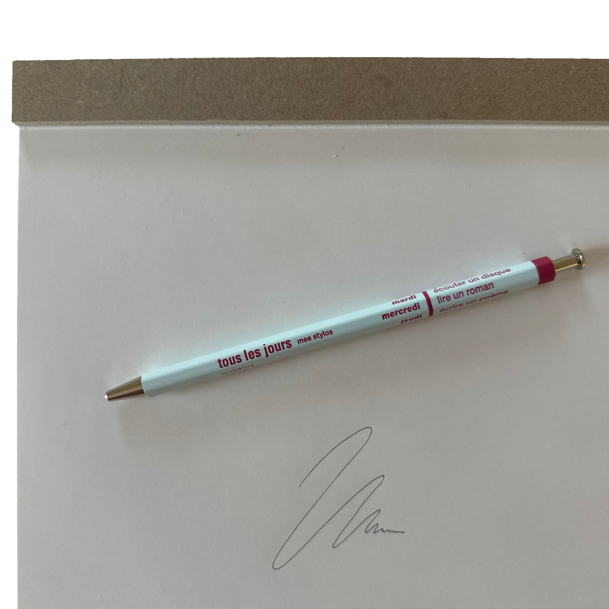 Light blue pen with red text on a white surface
