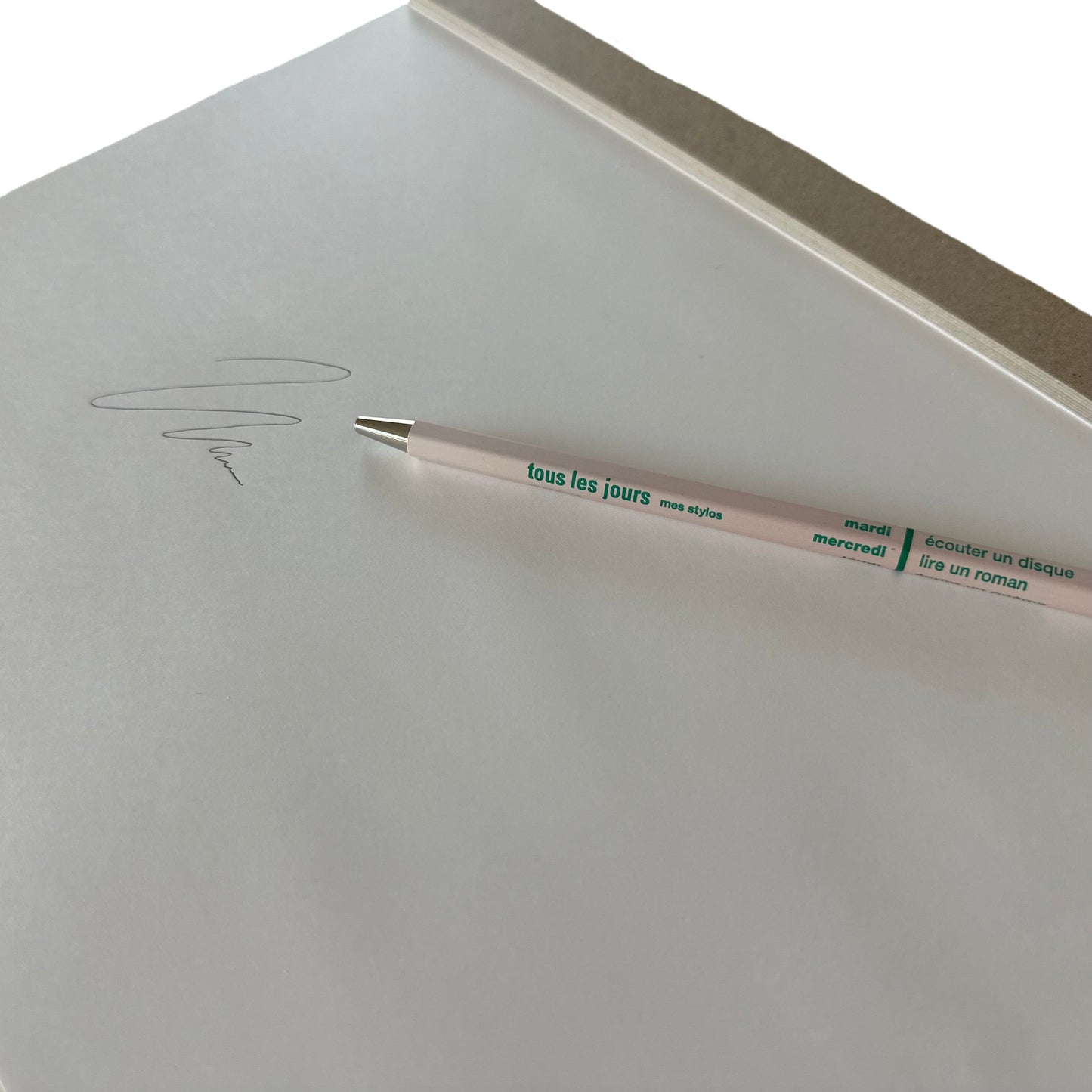 Light pink pen with text on a white surface