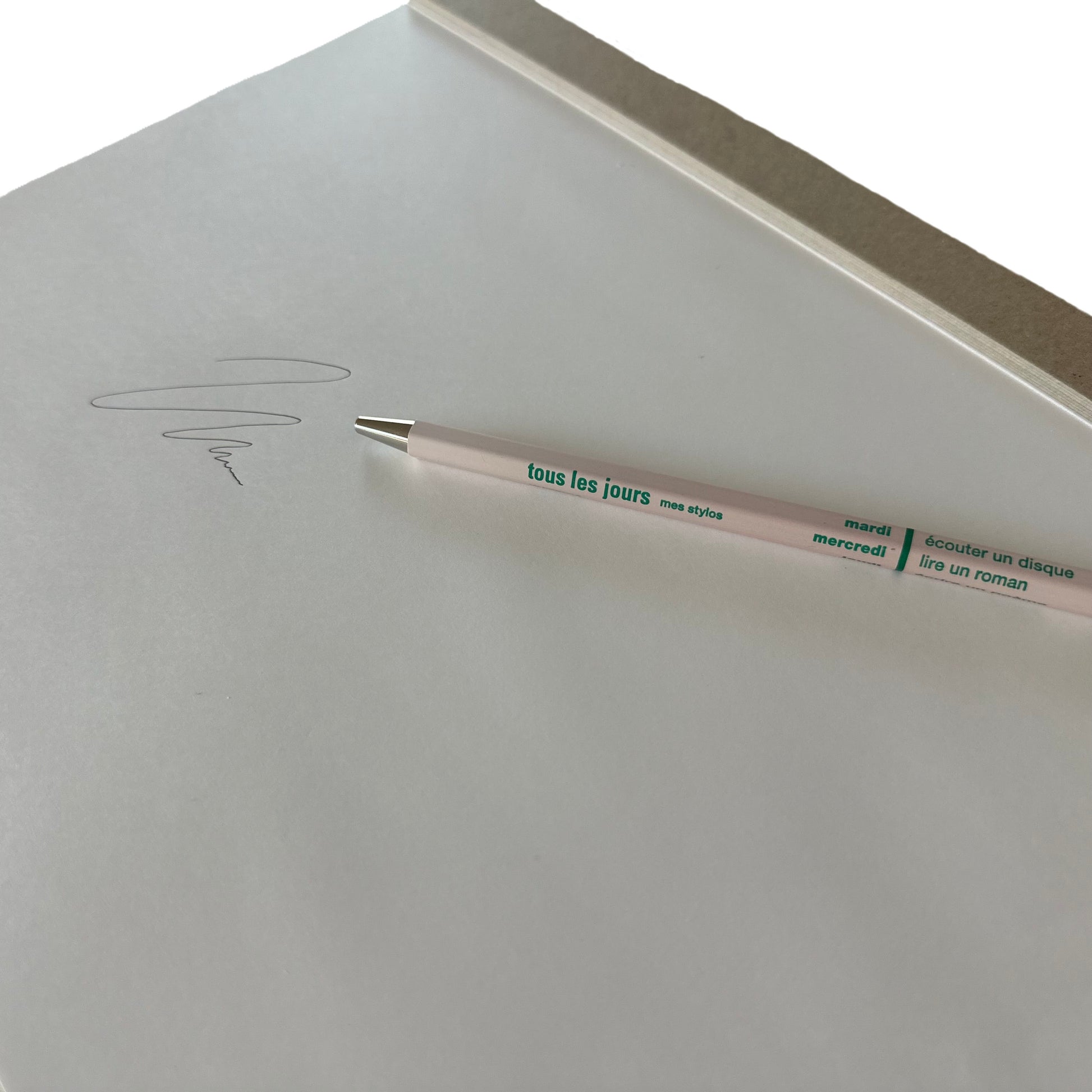 Light pink pen with text on a white surface