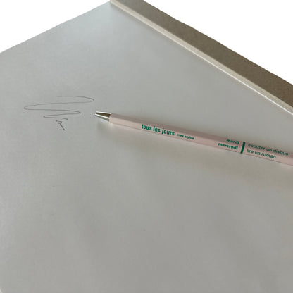 Light pink pen with text on a white surface