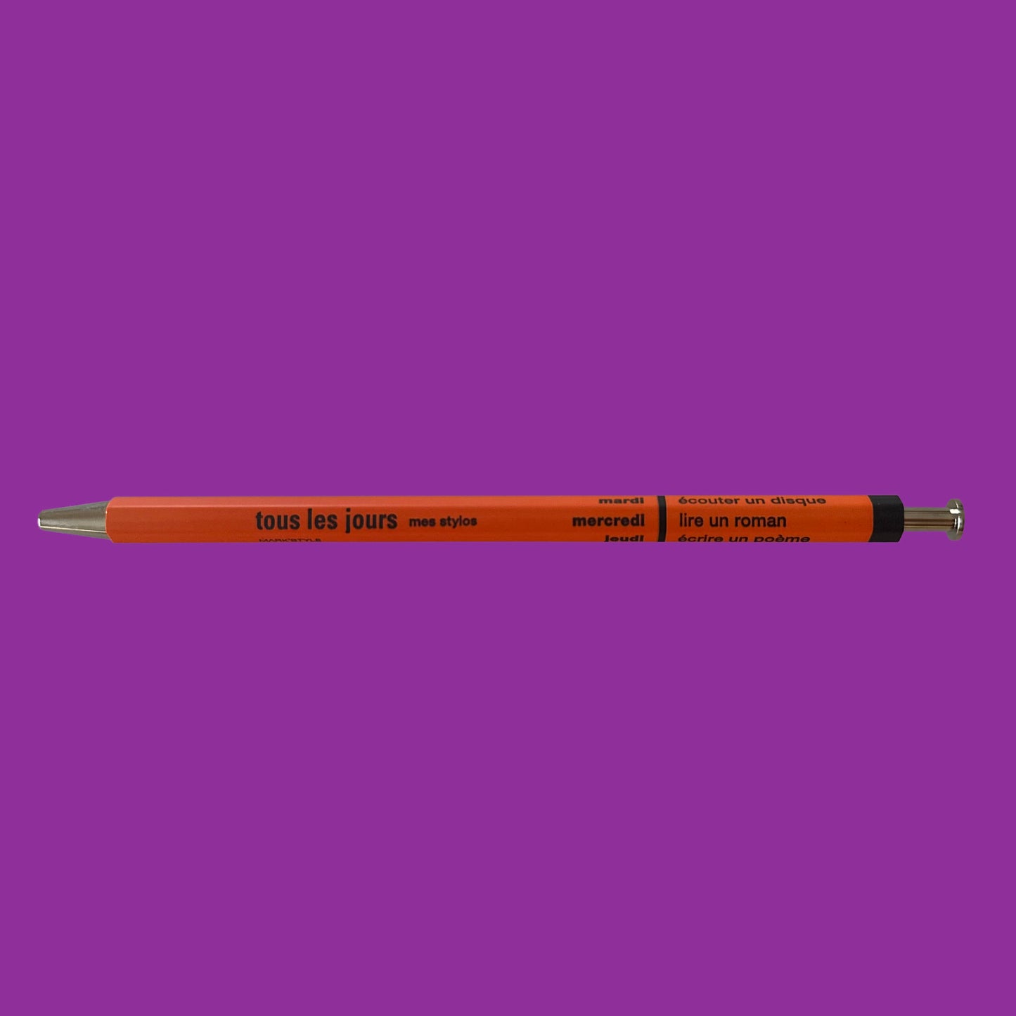 Image of orange ballpoint pen against a purple background