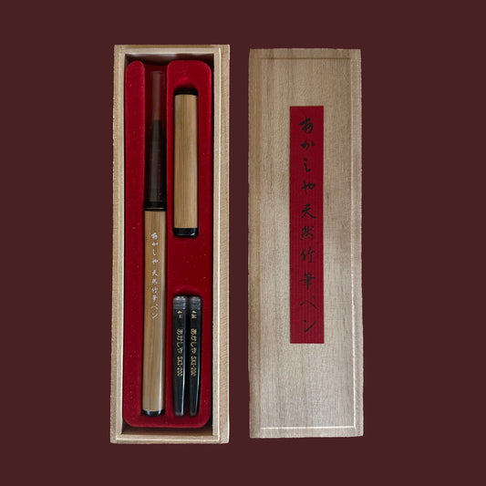 Calligraphy set with pen and ink stones in a wooden box on a dark red background