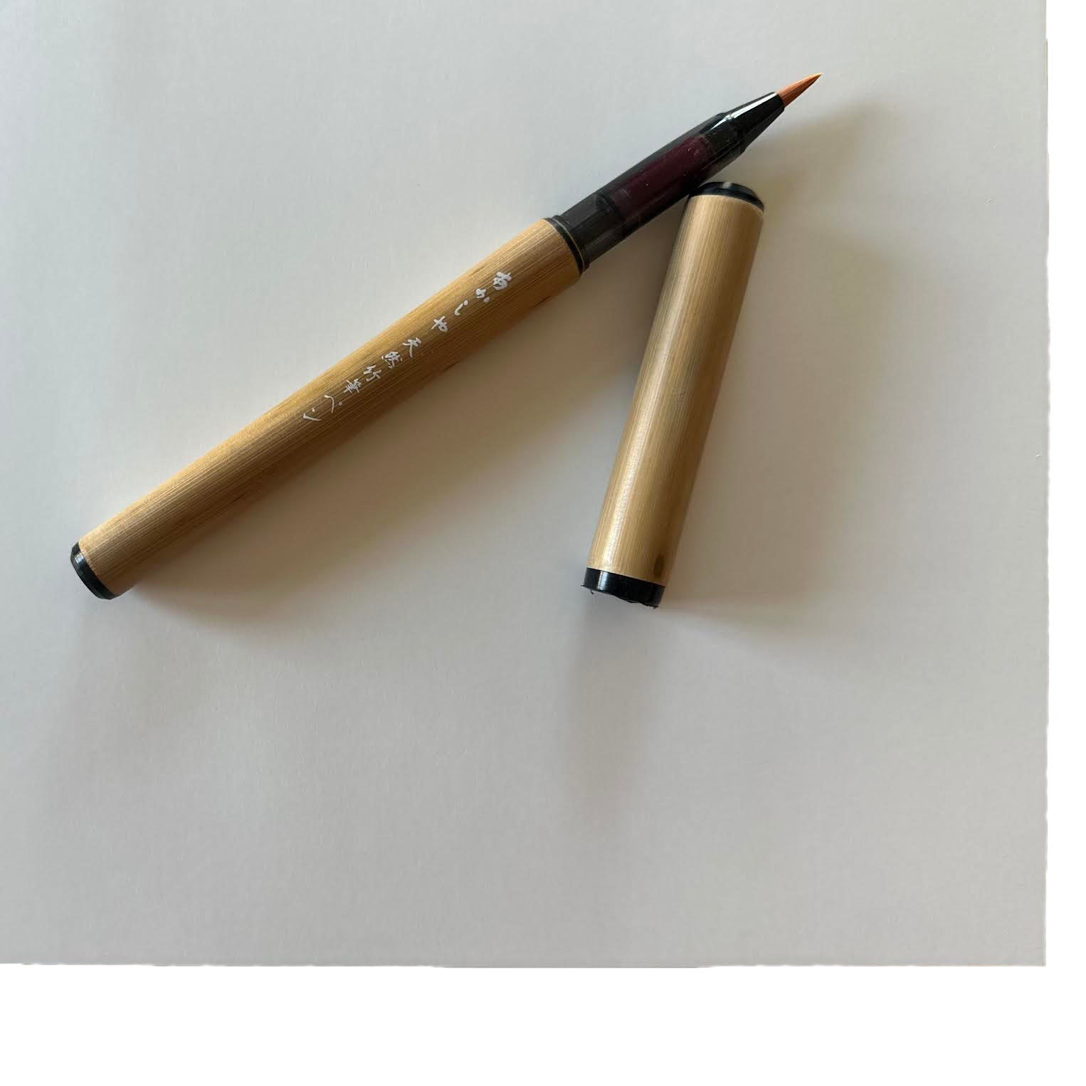 Bamboo pen with wooden barrel and black accents on a white background