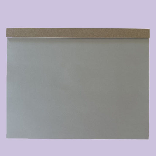 Gray drawing pad with a brown accent on a light purple background