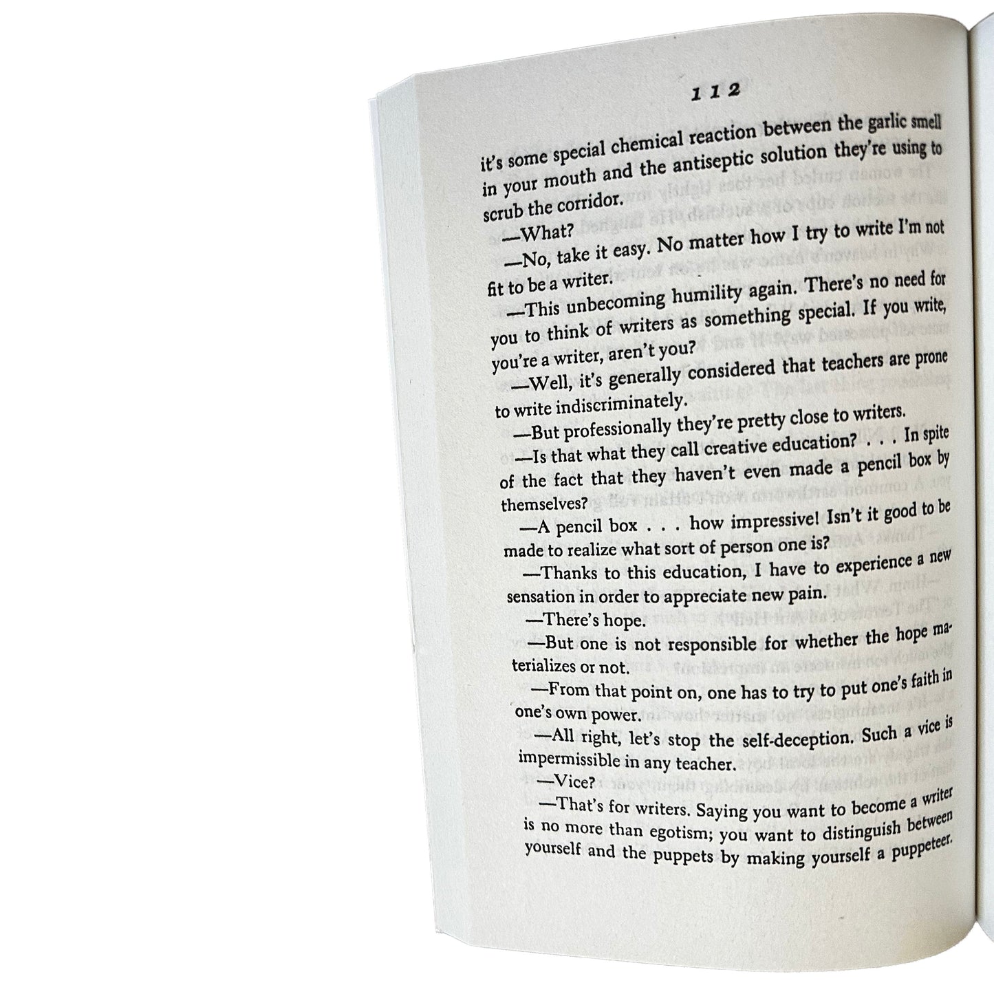 Open copy of The Woman in the Dunes with text on a white background