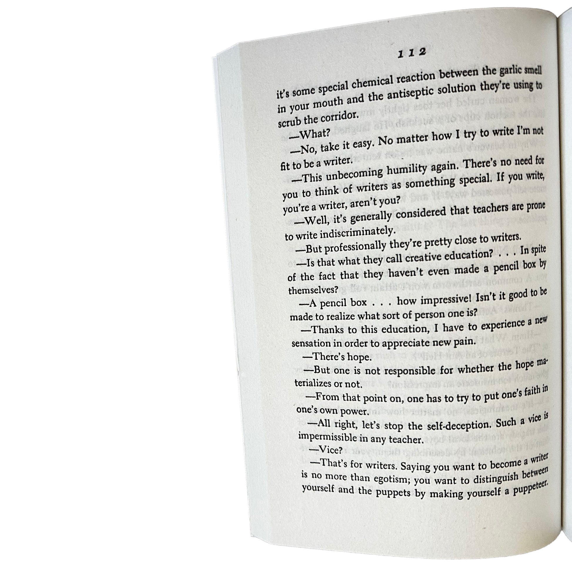 Open copy of The Woman in the Dunes with text on a white background