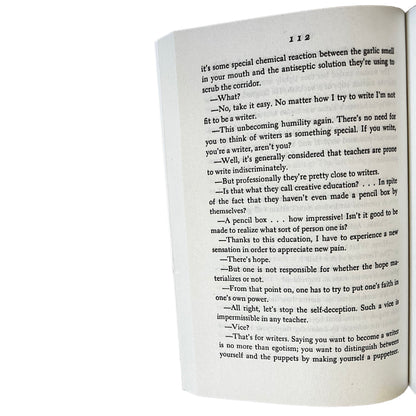 Open copy of The Woman in the Dunes with text on a white background