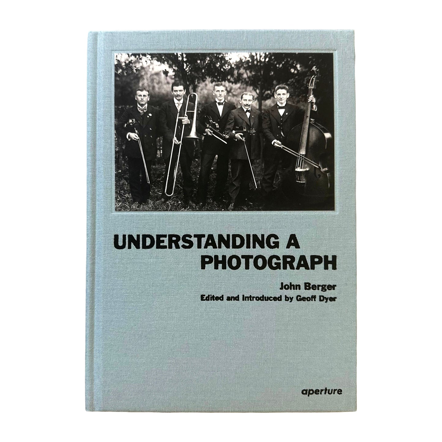 Book cover of 'Understanding a Photograph' by John Berger with a black and white photo of men in suits.